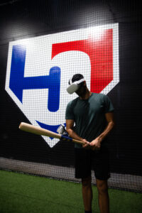 Baseball player in WIN Reality VR training headset with bat