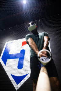 Baseball player in WIN Reality VR training headset with bat